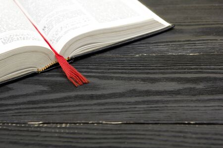 Composition with vintage old hardback books, diary, fanned pages on wooden deck table and red...
