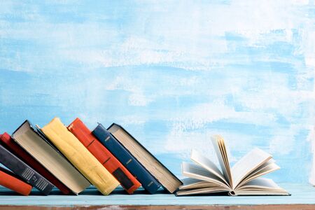 Composition with vintage old hardback books, diary, fanned pages on wooden deck table and abstract background. Books stacking. Back to school. Copy Space. Education background.の写真素材