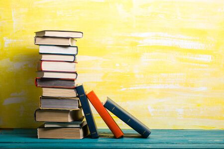 Composition with vintage old hardback books, diary, fanned pages on wooden deck table and abstract background. Books stacking. Back to school. Copy Space. Education background.の写真素材