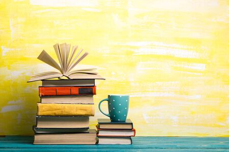 Composition with vintage old hardback books, diary, fanned pages on wooden deck table and red background. Books stacking. Back to school. Copy Space. Education backgroundの写真素材