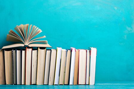 Composition with vintage old hardback books, diary, fanned pages on wooden deck table and abstract background. Books stacking. Back to school. Copy Space. Education background.の写真素材