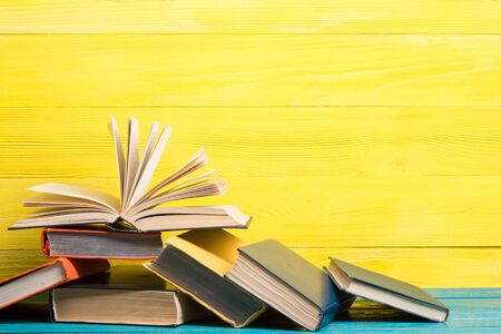 Composition with vintage old hardback books, diary, fanned pages on wooden deck table and abstract background. Books stacking. Back to school. Copy Space. Education background.の写真素材