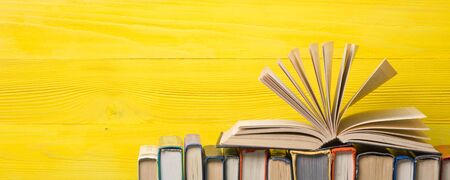 Composition with vintage old hardback books, diary, fanned pages on wooden deck table and abstract background. Books stacking. Back to school. Copy Space. Education background.の写真素材
