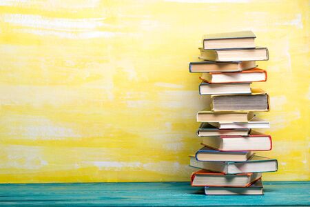 Composition with vintage old hardback books, diary, fanned pages on wooden deck table and red background. Books stacking. Back to school. Copy Space. Education backgroundの写真素材