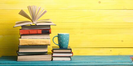 Composition with vintage old hardback books, diary, fanned pages on wooden deck table and red background. Books stacking. Back to school. Copy Space. Education backgroundの写真素材