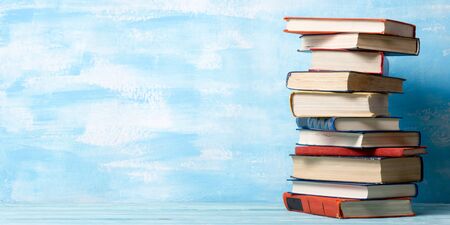 Composition with vintage old hardback books, diary, fanned pages on wooden deck table and abstract background. Books stacking. Back to school. Copy Space. Education background.の写真素材