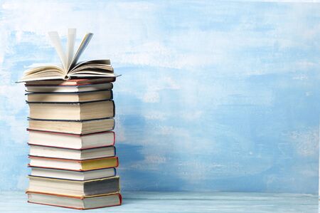 Composition with vintage old hardback books, diary, fanned pages on wooden deck table and abstract background. Books stacking. Back to school. Copy Space. Education background.の写真素材