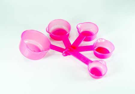 Pink measuring plastic spoons isolated on white backgroundの写真素材