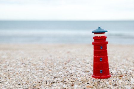 cute lighthouse figure on the beach in the eveningの写真素材