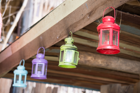 colorful metal lanterns suspended on wooden panelの写真素材