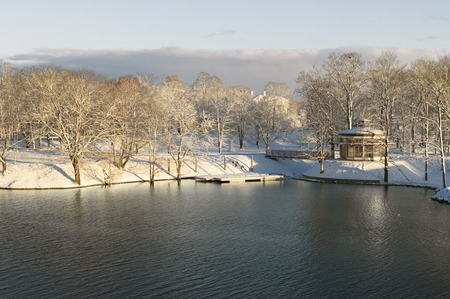 snow covered trees and a house by the river.の写真素材