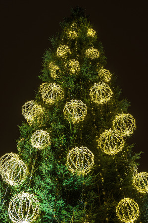 Christmas tree with electric decorations, lights in the night sky backgroundの写真素材