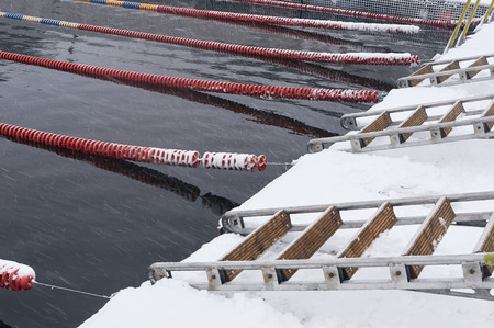 Winter swimming pool snowfall. Swimming pool in winter with snow. Swimming pool for winter sports....
