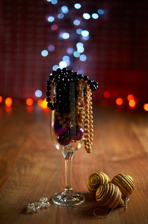 Glass of champagne with pearl beads, Christmas tree decorations and bokeh. Selective focusの写真素材