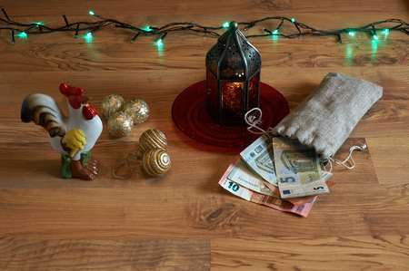 Red lantern with a rooster, money and Christmas lightsの写真素材
