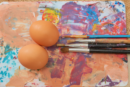 Painting Easter eggs: Brush on colors with eggs in the background. The color paletteの写真素材