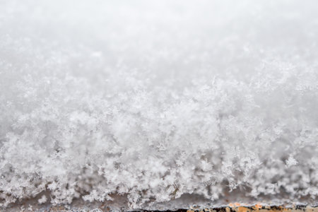 close-up photograph of a snow texture, individual flakes are visible, macro photography taken from...