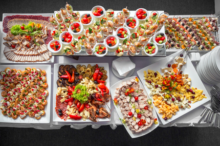 Authentic buffet, assorted fresh fruits, berries and citrus fruits. Morning atmospheric lighting, fashionable trendy spot soft focus. Preparation for design creative menu.の写真素材