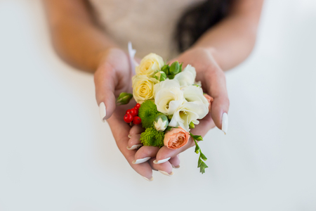 Bride holding a buttonhole. Gentle hand of the bride holding boutonniere for the groomの写真素材