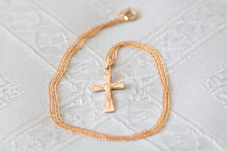 Christening details. Golden cross on a white canvasの写真素材