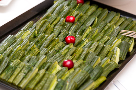 Sliced cucumbers on the tray are decorated with cherriesの写真素材