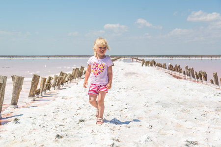 Little girl on the background of salt lakes of the dead sea and pink roseの写真素材