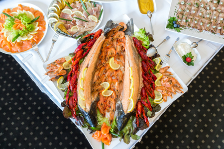 Shrimp, Crayfish, Salmon on a buffet table decorated with lemon, on a white plateの写真素材