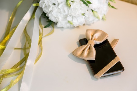 Accessories grooms wedding day. Mobile phone and butterflyの写真素材