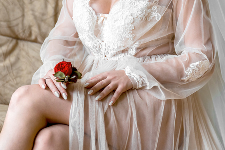 Bride holding a buttonhole. Gentle hand of the bride holding boutonniere for the groomの写真素材