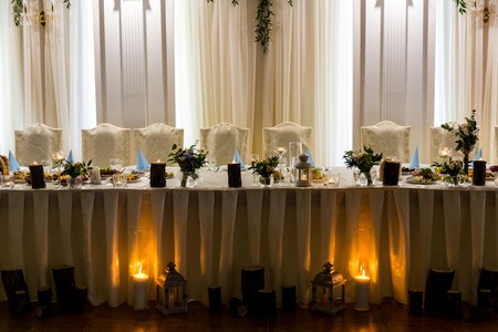 Beautiful wedding table for newlyweds is illuminated by candlesの写真素材