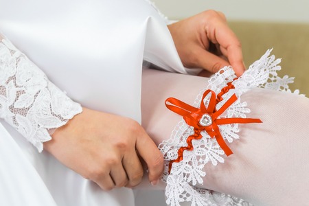 Bride wearing wedding garter. A woman demonstrates her sexy legsの写真素材