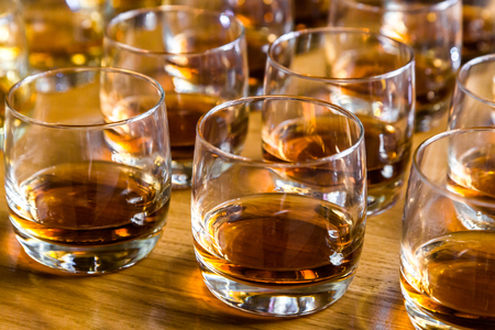 Glasses are filled with whiskey on the tableの写真素材