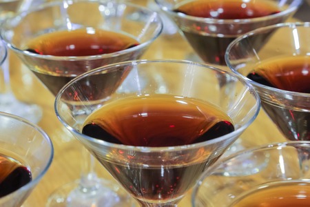 Several glasses of the famous Martini cocktail stand on a bar tableの写真素材