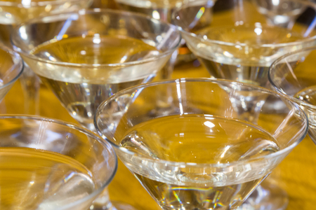 Several glasses of the famous Martini cocktail stand on a bar tableの写真素材