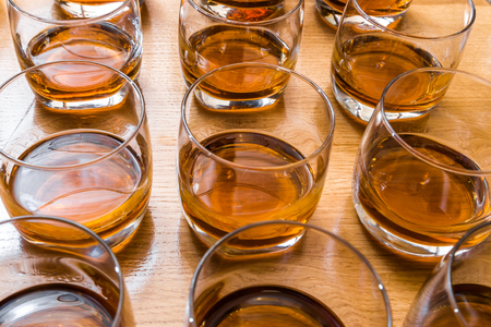 Glasses are filled with whiskey on the tableの写真素材