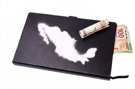 Map of mexico made of cocaine on a black notebook from which some bills come out 