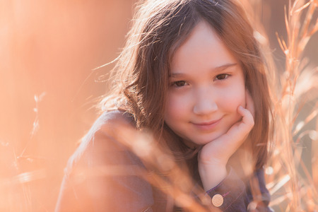 A beautiful young girl smiling at the camera on a sunny day.の写真素材