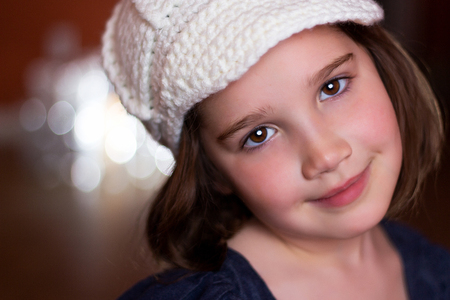 Portrait of a beautiful young child in a woven hat looking at cameraの写真素材
