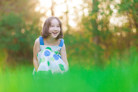 A beautiful young happy girl smiles looking off into the distance.の写真素材