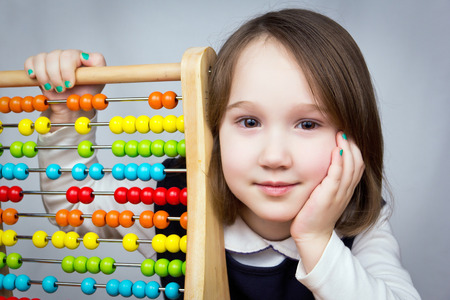 A young girl with an abacus looking at the camera.の写真素材