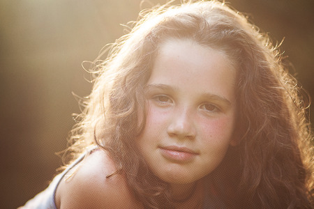 Beautiful confident young girl looking at camera on a sunny dayの写真素材