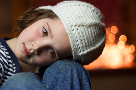 Portrait of a beautiful young child with her head on her kneesの写真素材