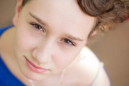 Gorgeous young girl with stunning eyes looking up at the camera.の写真素材