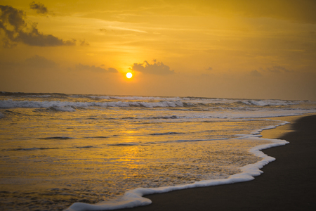 Sunset on the beach with waves crashingの写真素材