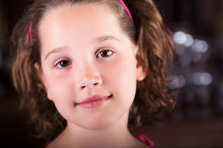 Beautiful young girl looking peacefully at the cameraの写真素材