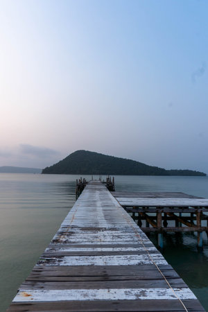 Wooden pontoon advancing into the sea, with an island visible on the horizon.の写真素材