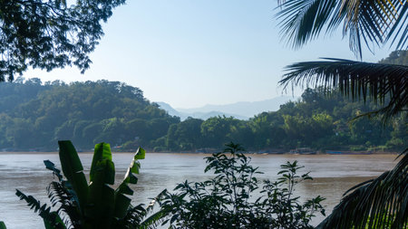 View on the mekong river and on the mountains, with leaves in the foreground, in Vang Vieng, Laos.の写真素材