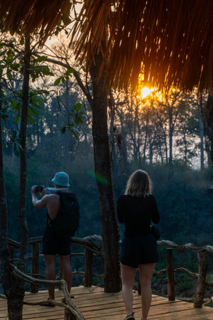 Guy with a green hat taking picture of Tad Lo Waterfall on a bridge, near Pakse, Laos.の写真素材