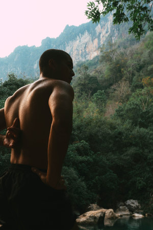 Sporty guy view from back, with mountains in the background, Thakhek loop, Laos.の写真素材