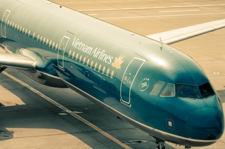 A Vietnam Airlines plane waits at the gate for passengers to board.のeditorial素材